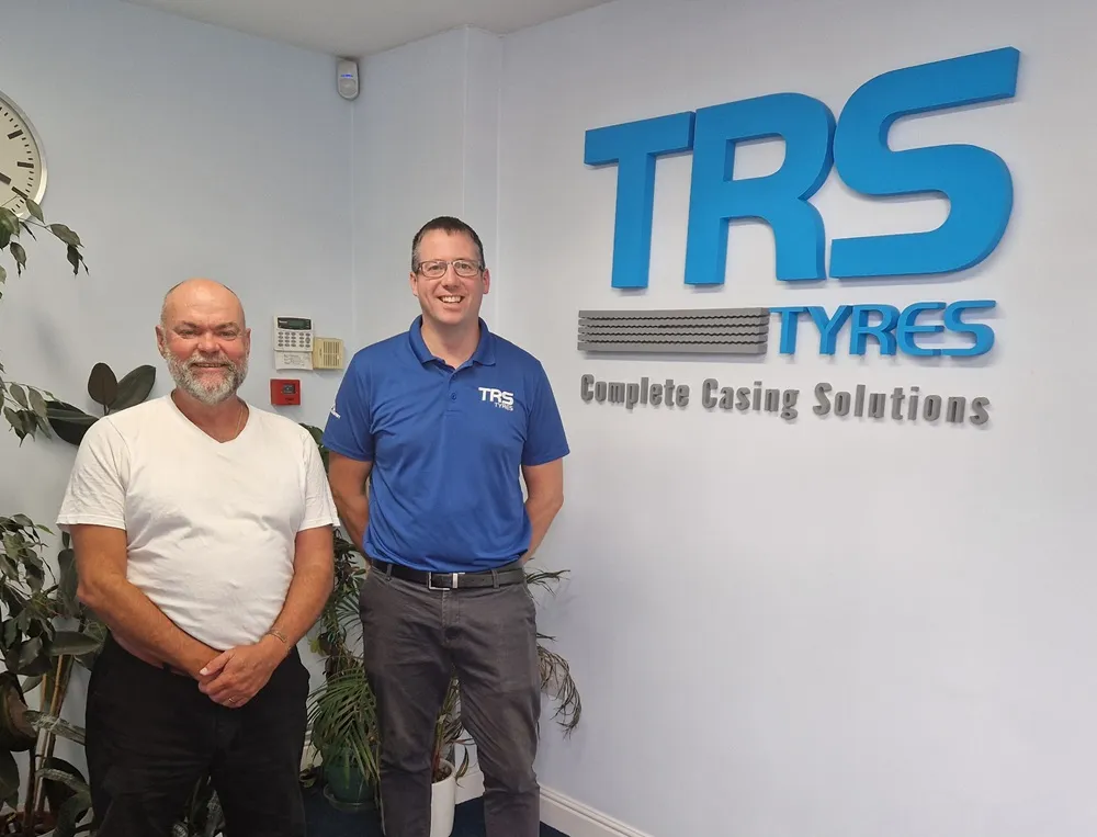 TRS Tyres and Fitter Force people stood in front of a TRS Tyres logo