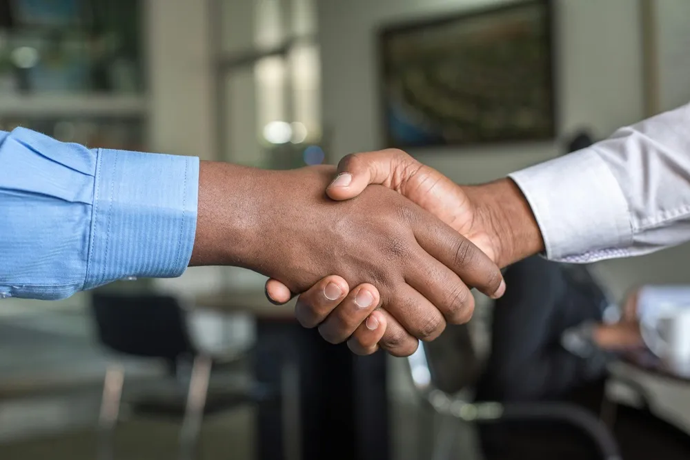 Image of a handshake between people wearing shirts