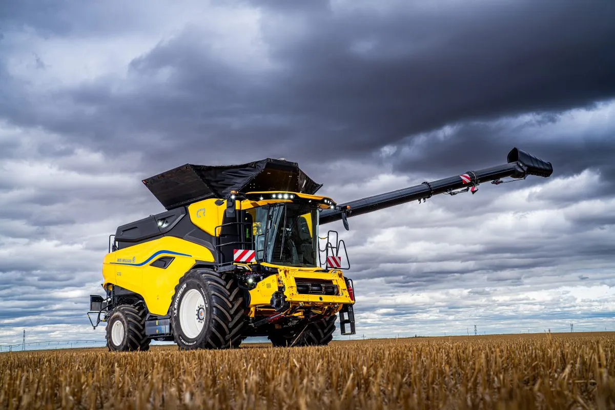 Yellow New Holland Combine Harvester with Michelin Tyres in a field of wheat