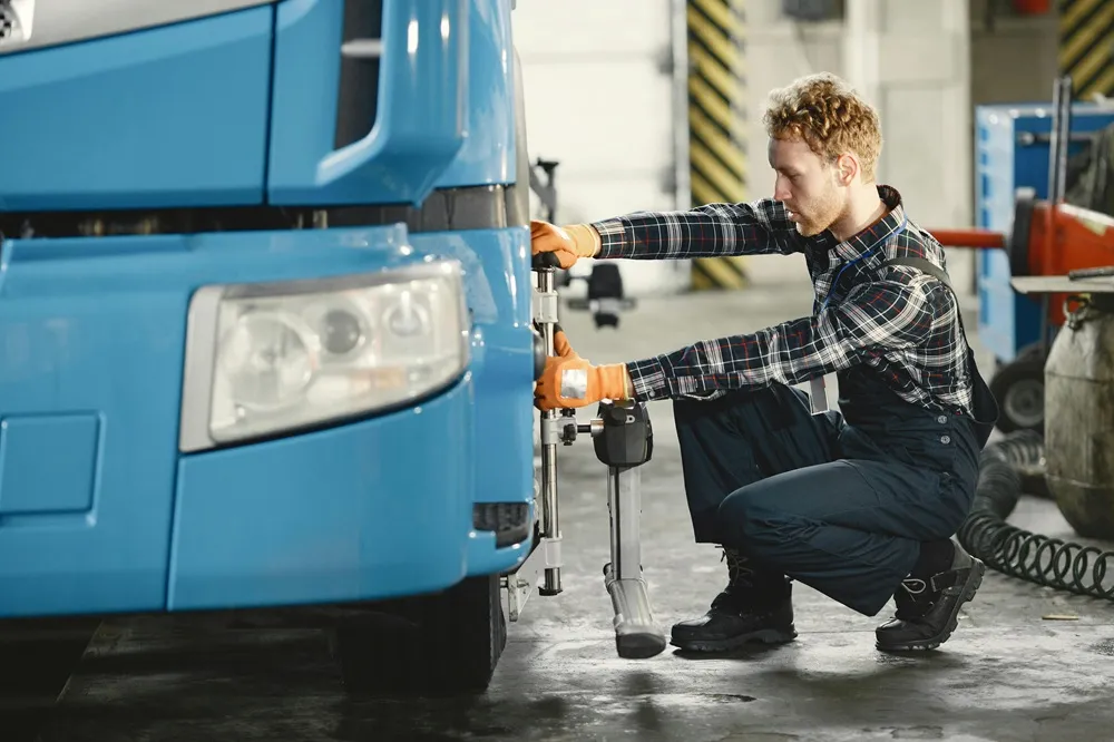 Mechanic inspecting a truck's tyre