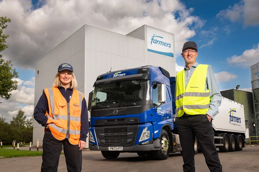 Naeve Brown from ForFarmers UK with Wayne Bell from Prometeon Tyre Group in front of a blue lorry with white trailer.