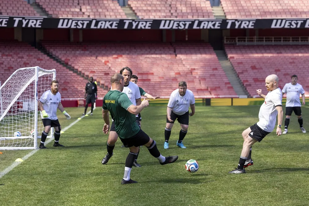Image of people playing football near the goalat Emirates Stadium