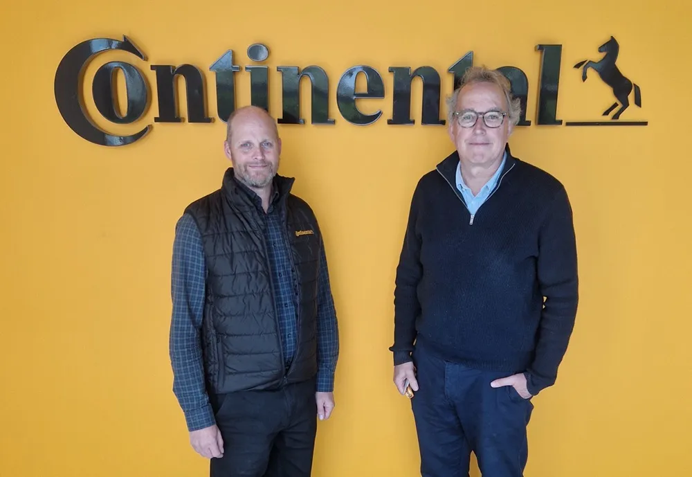 Ian Jackson and Steve Howat stood in front of a yellow background with a black Continental sign