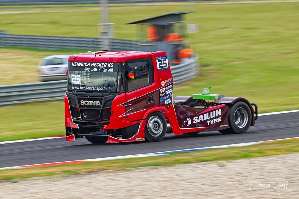 Image of a SAILUN branded Team Hecker racing truck from the side driving on the Nürburgring.