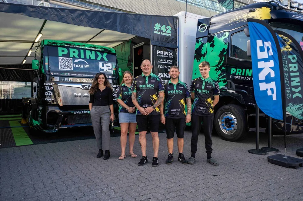 Image of the PRINX racing team display with five members of PRINX stood in front of two trucks