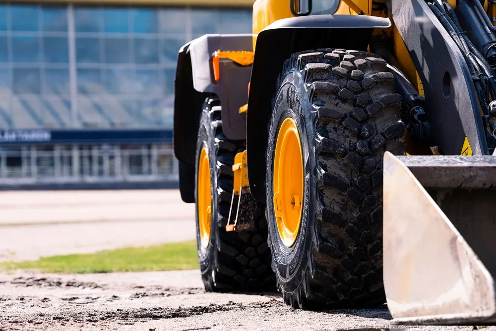 Close up of a construction vehicle's tyres wih yellow wheels